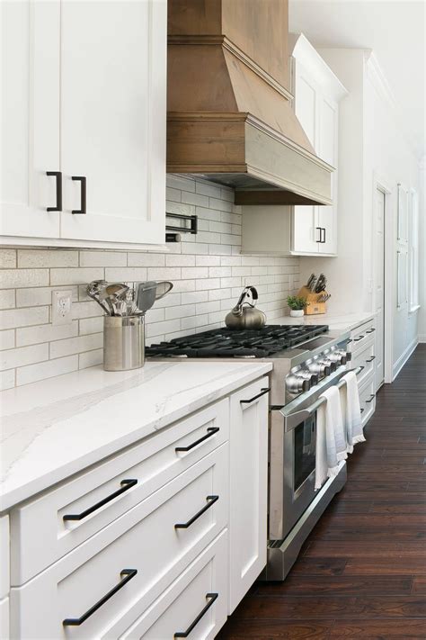 black handles on white kitchen cabinets with stainless steel appliances|white cabinets with black knobs.